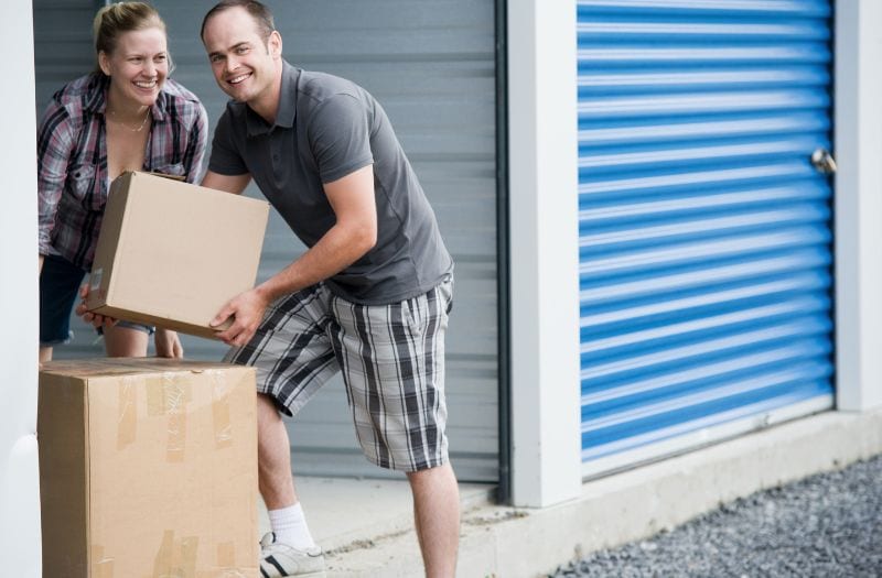 couple putting boxes in a self storage unit